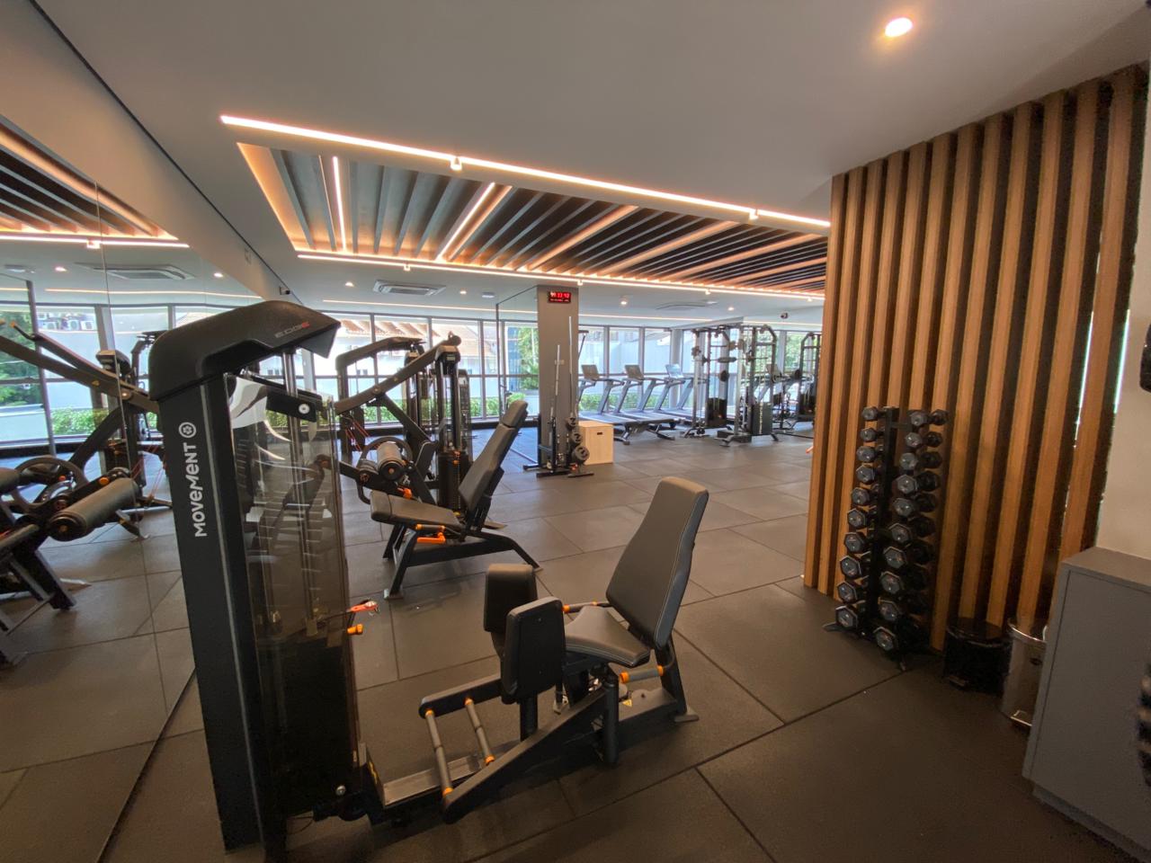 Vista ampla de academia de condomínio equipada pela Shaper com esteiras e estações de musculação
